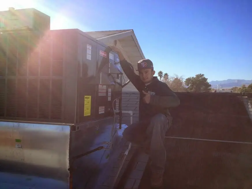 HVAC technician performing Air Duct Repair on a rooftop unit in Timberlake